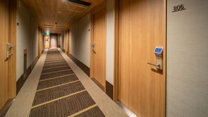 A hotel corridor with wooden doors, numbered 806, and a carpeted floor. - Super Hotel Tottori Ekimae (Tottori)