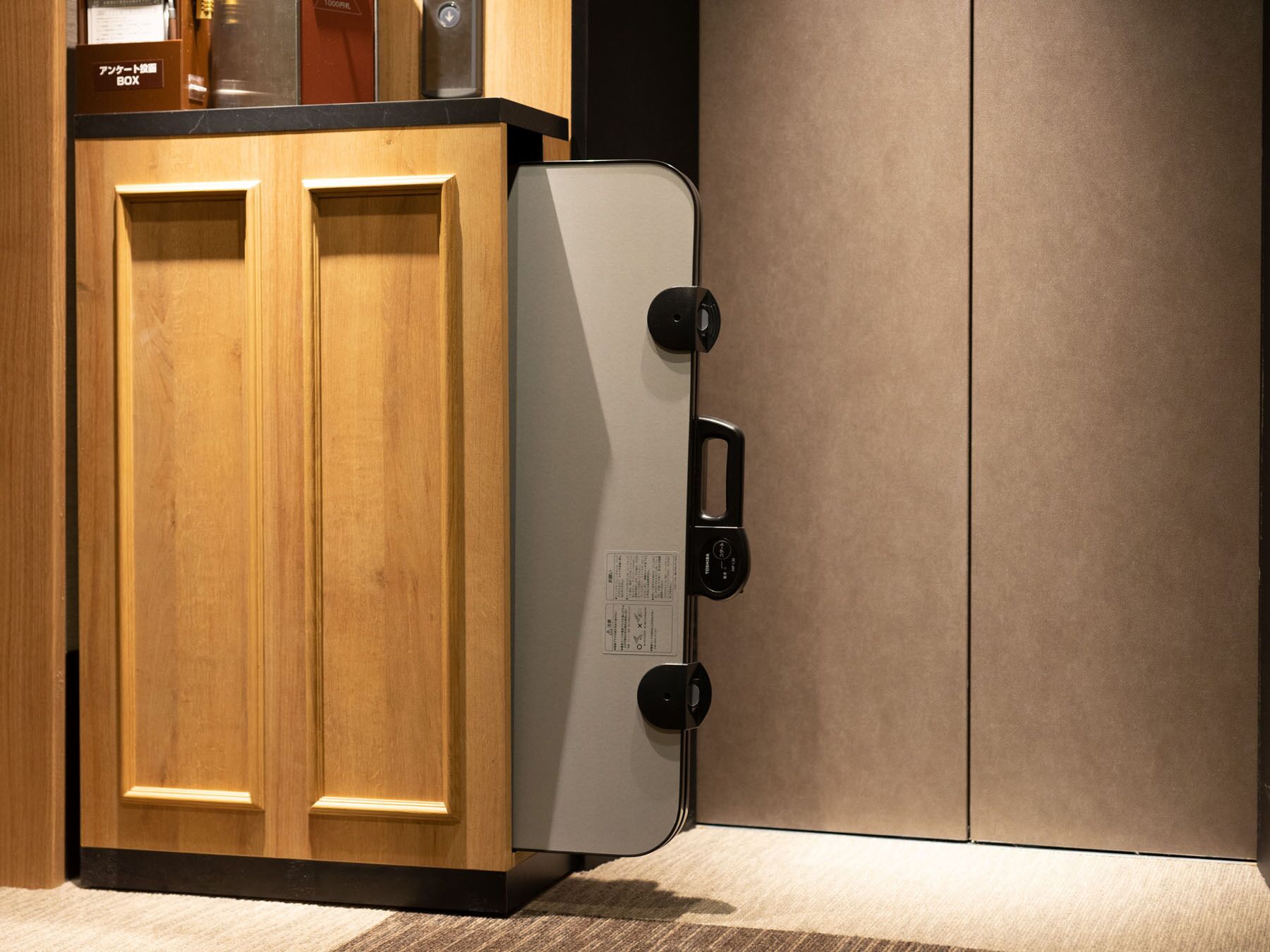A kitchen with wooden cabinets and a white appliance with a black handle.