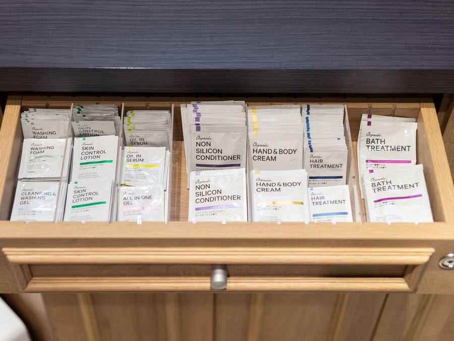 A drawer containing various organic personal care products such as skin control lotion, oil in serum, non silicone conditioner, hand and body cream, hair treatment, and bath treatment.