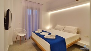Un dormitorio moderno con cama, una silla blanca y una cesta en la pared.
