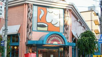 A building with a large coffee shop sign and a colorful mural.