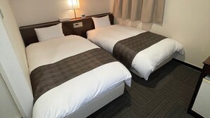 Una camera d'albergo con due letti, un comodino con lampada, una finestra con tende e un pavimento tappezzato.