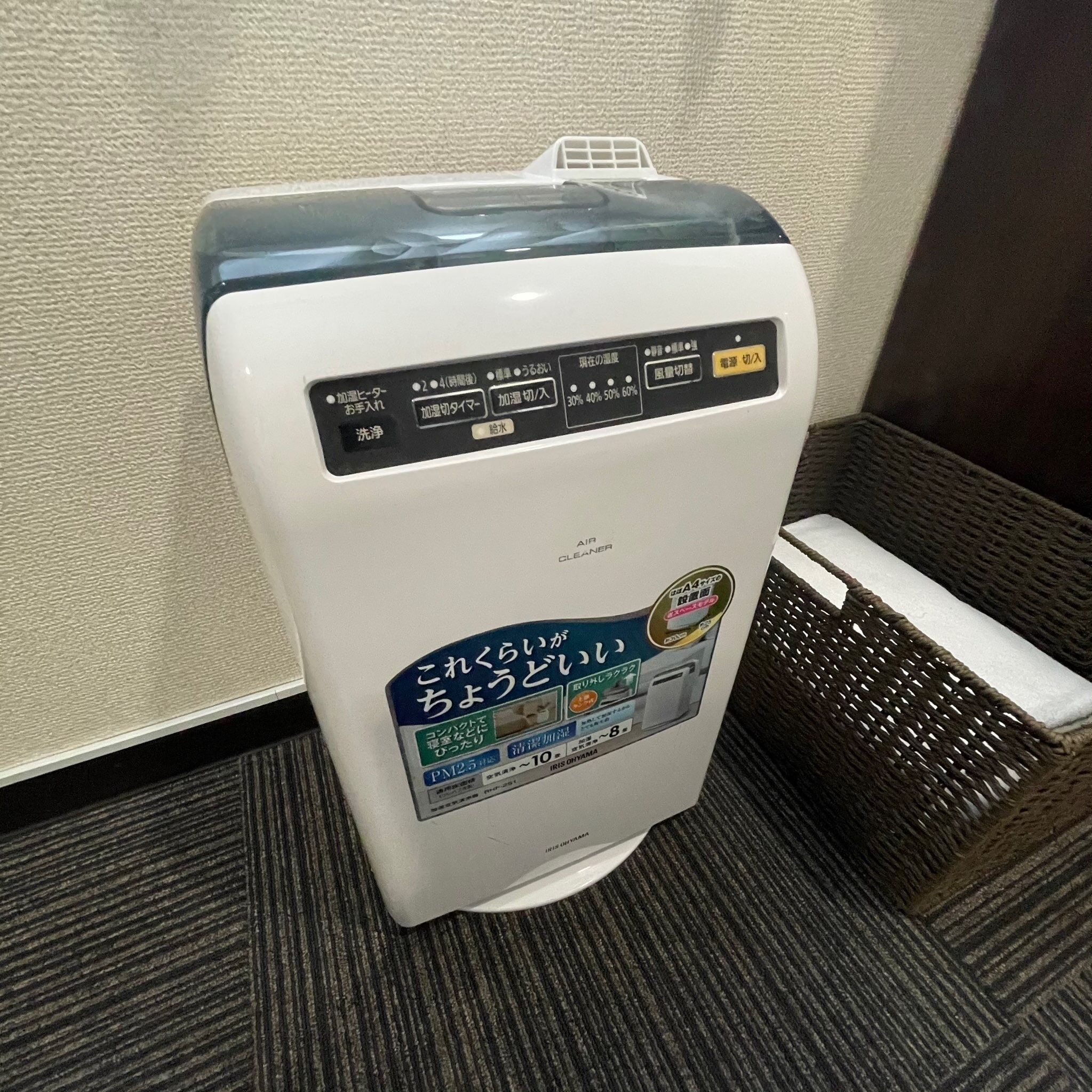 A white air purifier with Japanese instructions and a blue sticker advertising its features.