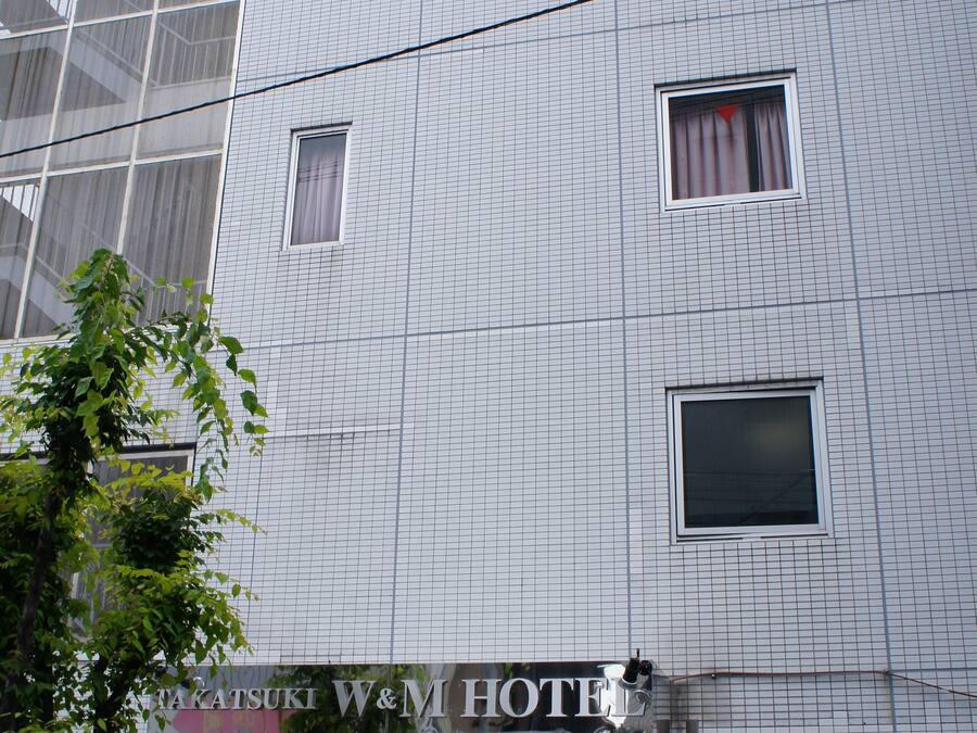A hotel with a grid-patterned facade, multiple windows, and a sign reading "W&M HOTEL".