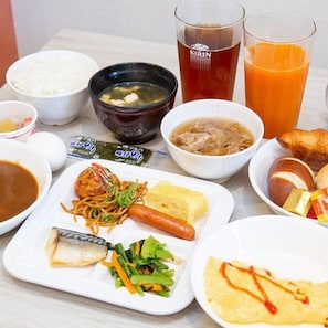 A table with various dishes including noodles, a hot dog, and a soup bowl. - Kuretake Inn Osaka Midosuji Honmachi (Osaka)