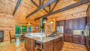 A spacious kitchen with wooden cabinetry, a large island, and pendant lighting.