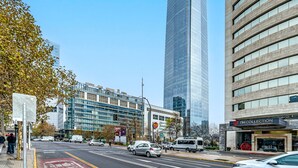 A modern urban street with tall buildings, a clear blue sky, and a pedestrian crossing. - Studio apartment renewed @ best location in Santiago (santiago)