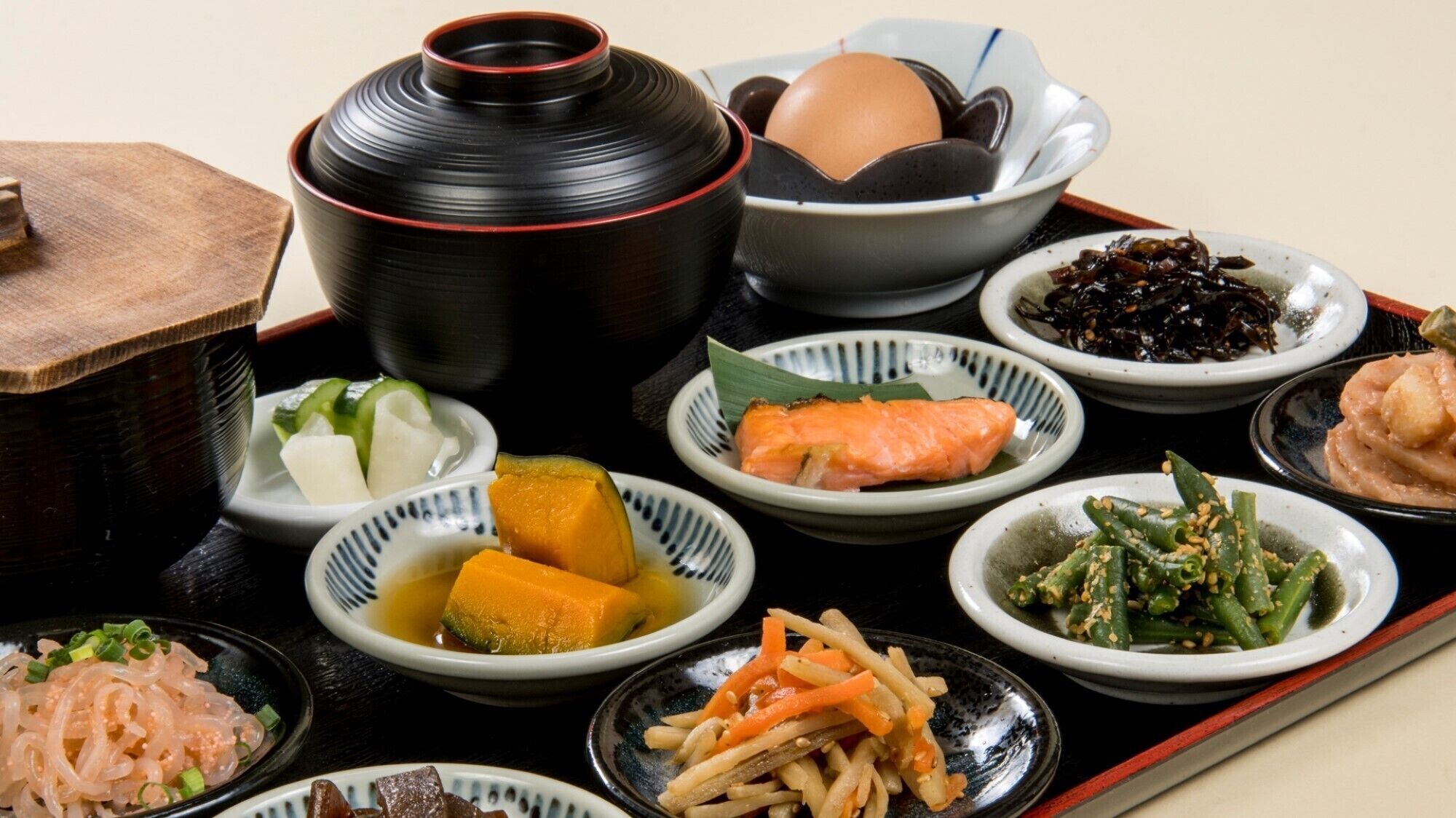 Una comida tradicional japonesa con diversos platos, incluyendo sashimi, verduras y una olla.