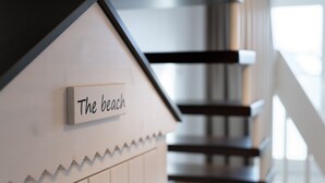 Een model van een strandhuis met een bord waarop staat 'The beach'.
