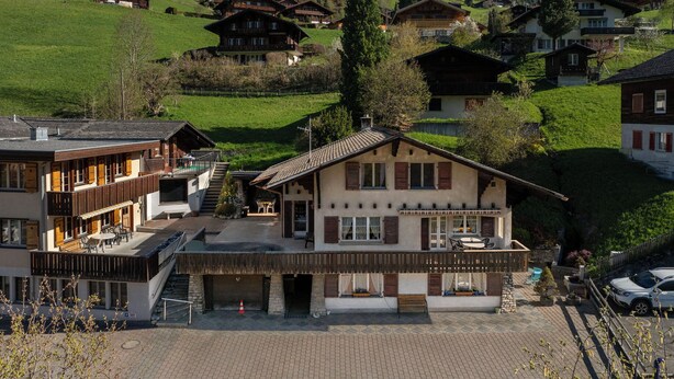 A hotel with a terrace, a mountain view, and traditional wooden architecture. - Strassscheuer by Interhome (Grindelwald)