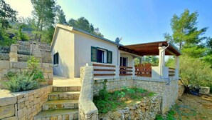 A stone staircase leading to a white building with a wooden porch. - Vacation home Flora by Interhome (Korcula/Vela Luka)