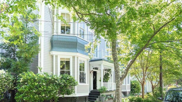 A two-story house with a bay window, a porch, and a small front yard. - Bright, Historic Row Home Minutes from Forsyth by Lucky Savannah (Savannah)