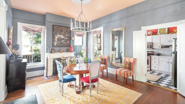 A dining area with a round table, chairs, and a chandelier. - Bright, Historic Row Home Minutes from Forsyth by Lucky Savannah (Savannah)