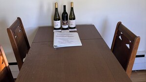 A dining table with three wine bottles and a welcome guide for a retreat. - Heart of the Seneca Lake Wine Trail (Burdett)
