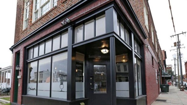 A corner building with large windows and a black awning.