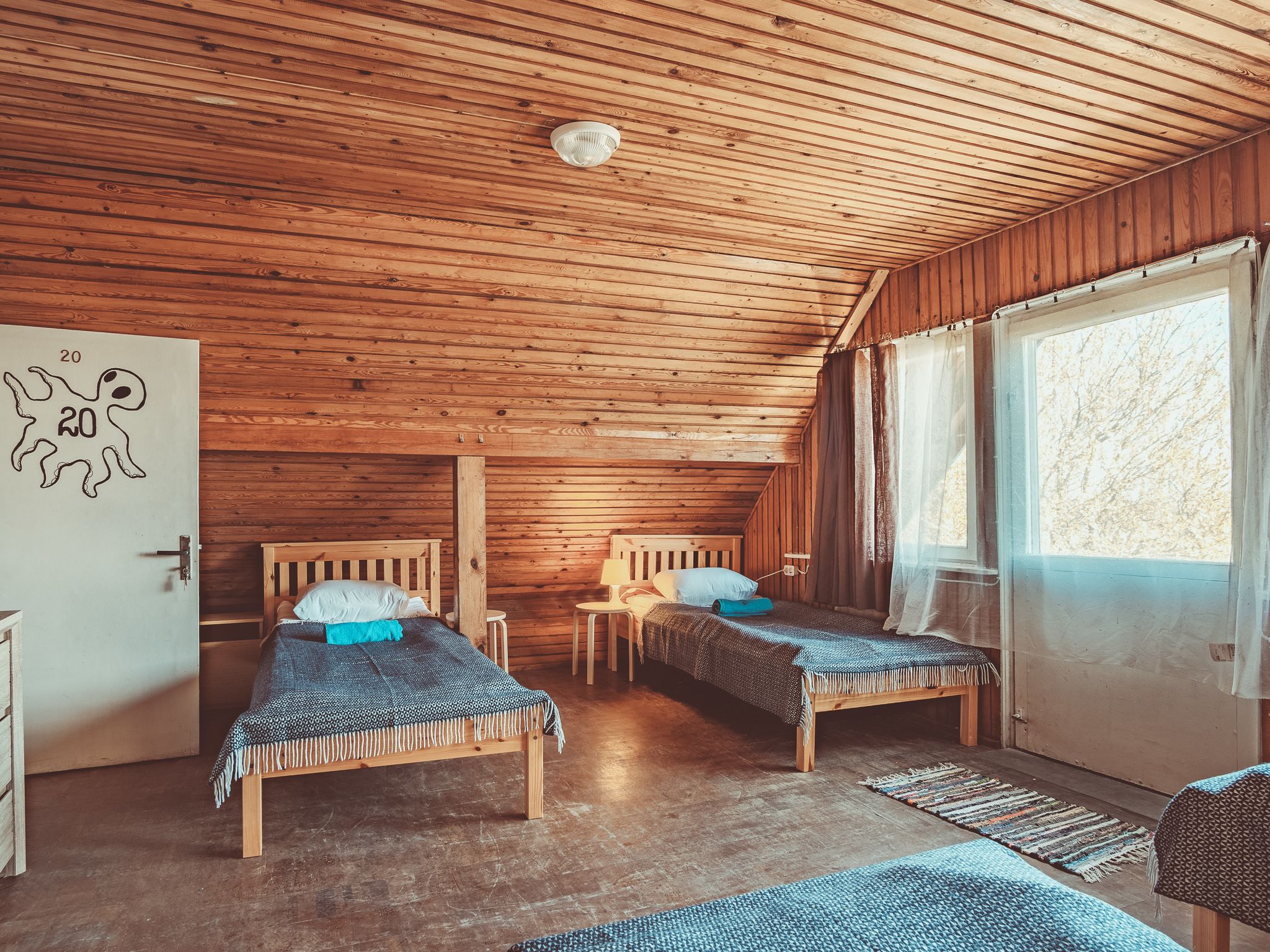 Eine Hütte mit zwei Holzbetten, einem kleinen Tisch und einer Tür, die mit der Nummer 20 gekennzeichnet ist.