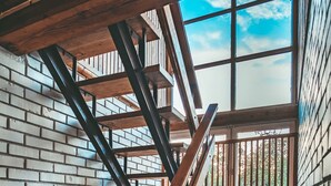 A wooden staircase with a view of greenery outside. - Guboja (Neringa)