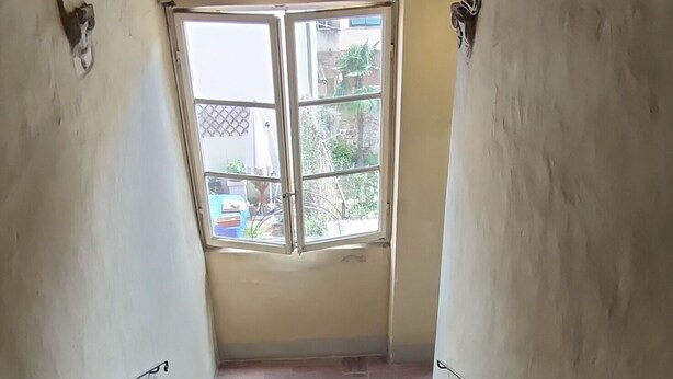 A staircase with a view of the outside through a window. - Tuscan style apartment in Centro Storico (Lucca)