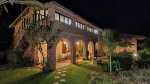 A stone building with arched walkways and a well-lit interior. - Villa Laura in Punta Tramontana - Castelsardo (CASTELSARDO)
