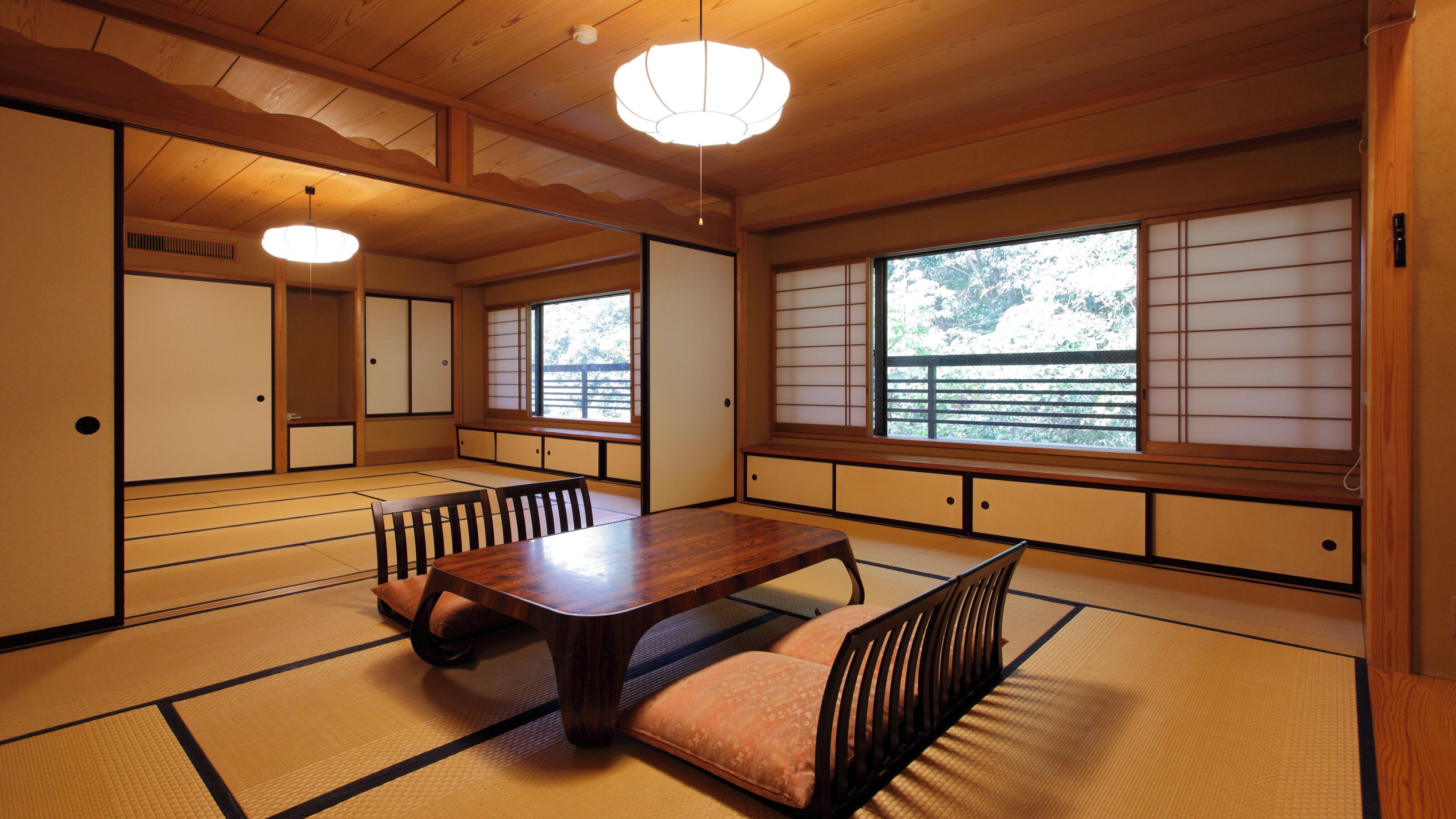 A traditional Japanese room with tatami flooring, a low wooden table, and sliding doors.