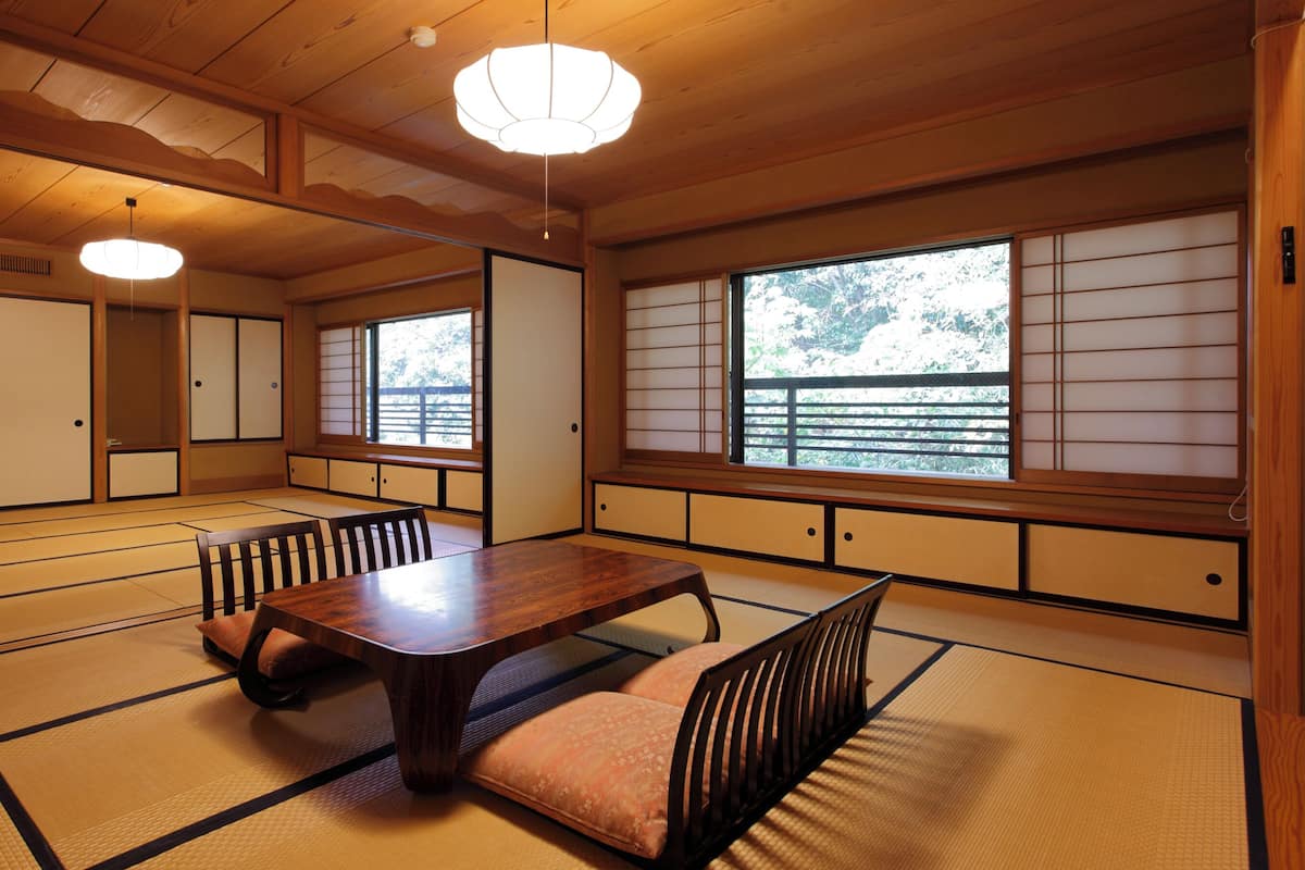 A traditional Japanese room with tatami flooring, a low wooden table, and sliding doors.