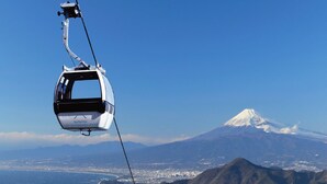 Eine Seilbahn mit Blick auf einen Berg und eine Stadt im Hintergrund.