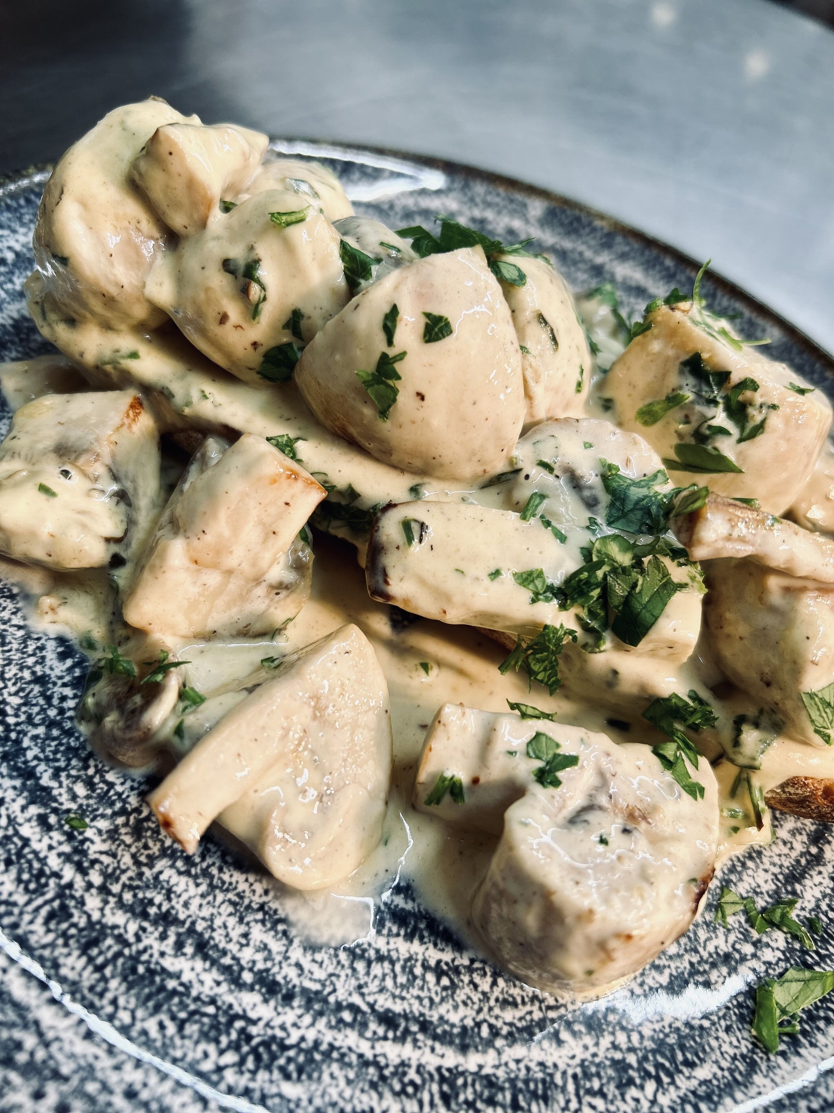 Un plato de comida con salsa cremosa y hierbas.