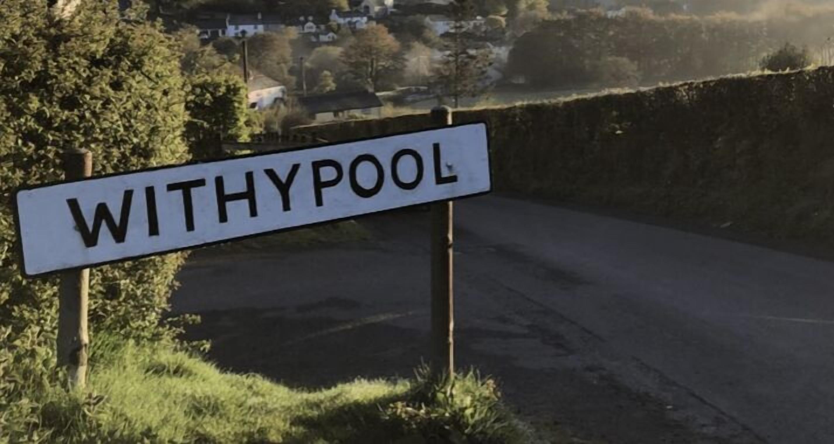 A sign with the name "WITHYPOOL" on a rural road.