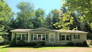 A single-story house with a front porch, a driveway, and a lawn.
