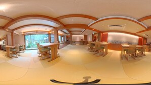 A spacious interior with a central dining area, kitchen, and large windows.