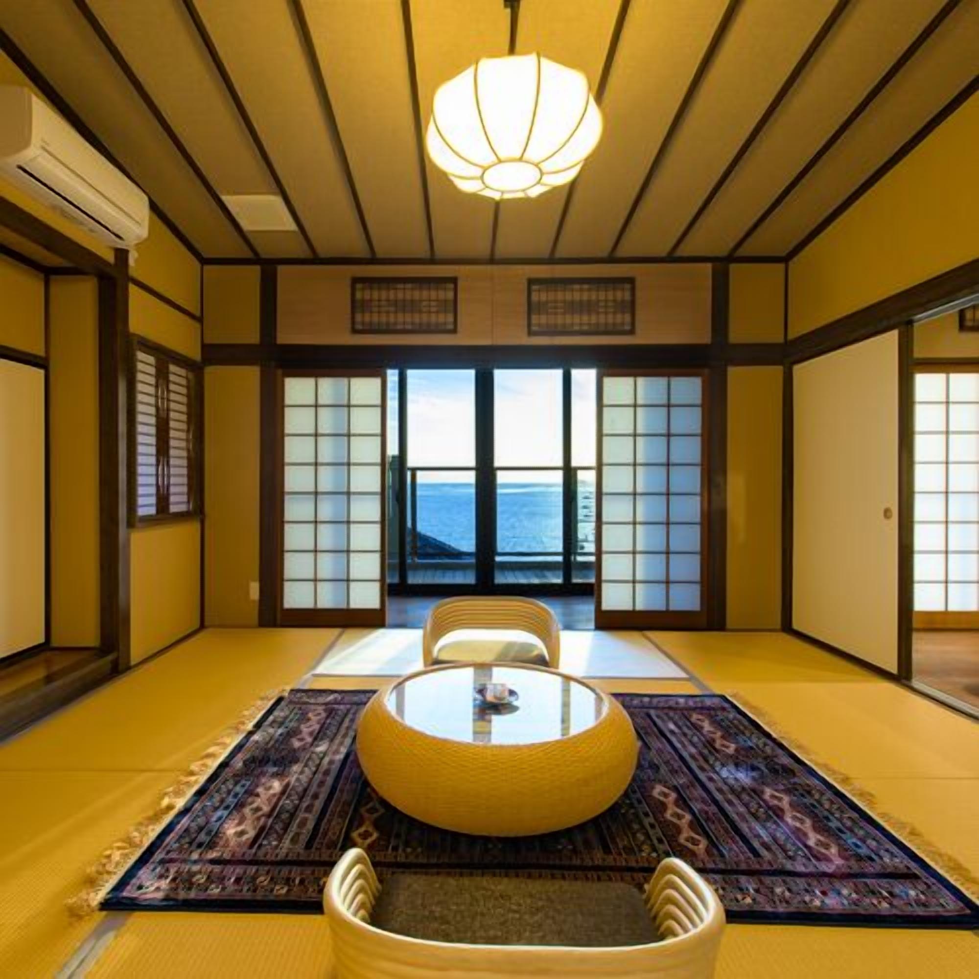A traditional Japanese room with tatami flooring, a low table with cushions, and a view of the sea through shoji screens.