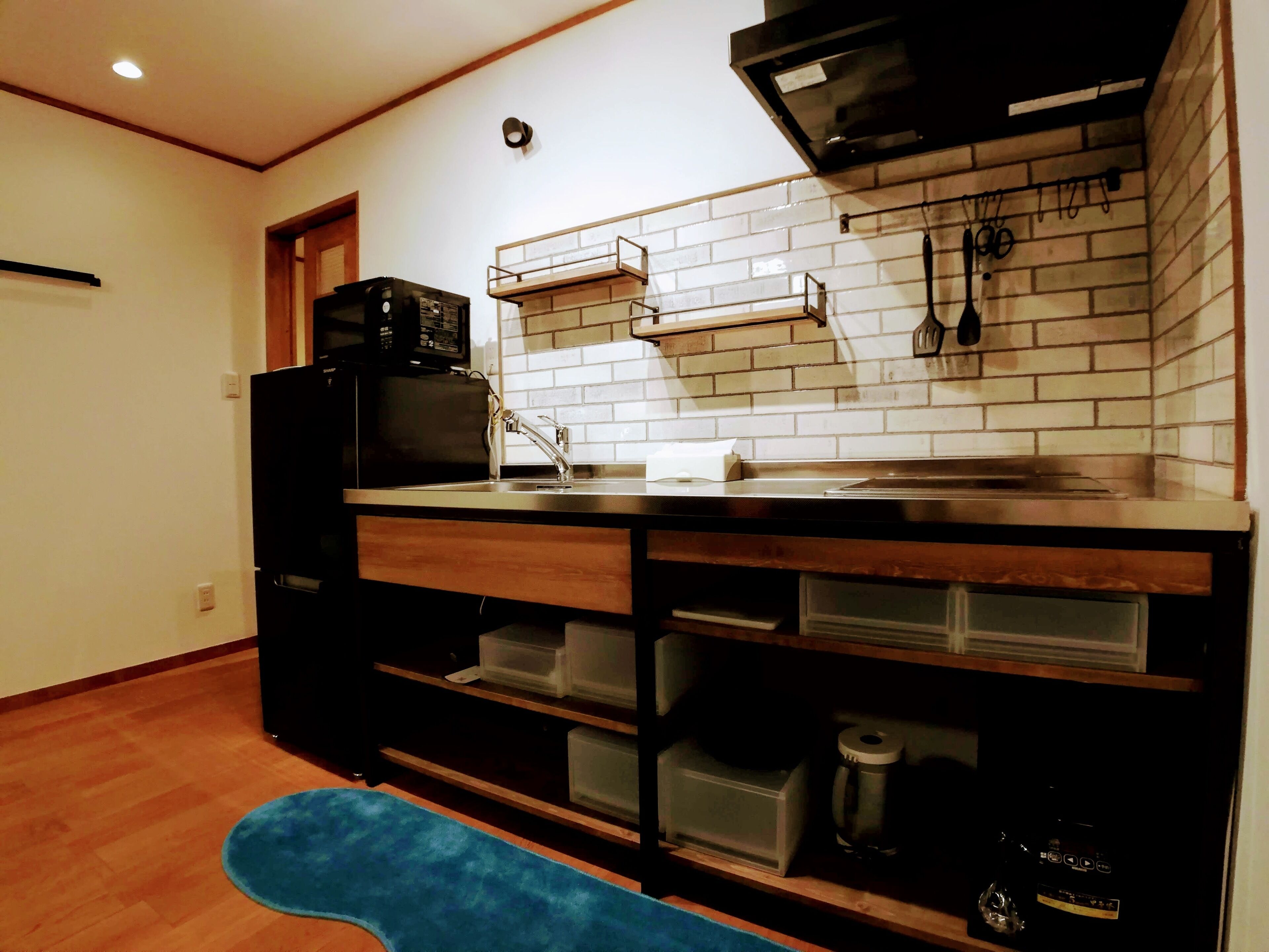 A kitchen with a microwave, sink, and storage drawers.