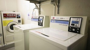 A laundry facility with two washing machines, a dryer, and a water meter. - Yokkaichi Urban Hotel (Yokkaichi)
