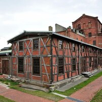 Un edificio histórico con entramado de madera a la vista y ventanas amplias.