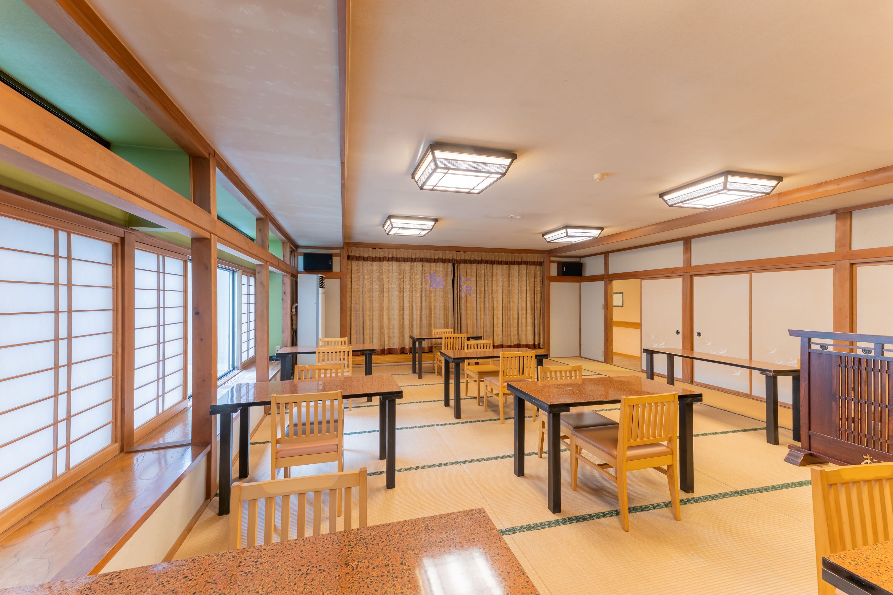 A traditional Japanese room with tatami flooring, wooden furniture, and shoji screens.