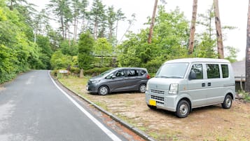A road with two parked vehicles, a car and a van, on the side.