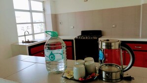 A kitchen with a water dispenser, a coffee maker, and a kettle on the counter. - Hotel y Suites Axolotl (Chignahuapan)
