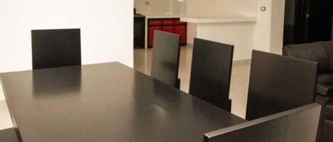A modern dining area with a long table and six chairs.