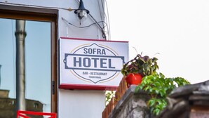 A hotel entrance with a sign reading "SOFRA HOTEL BAR - RESTAURANT TRADITIONAL." - Hotel Sofra (Gjirokastër)