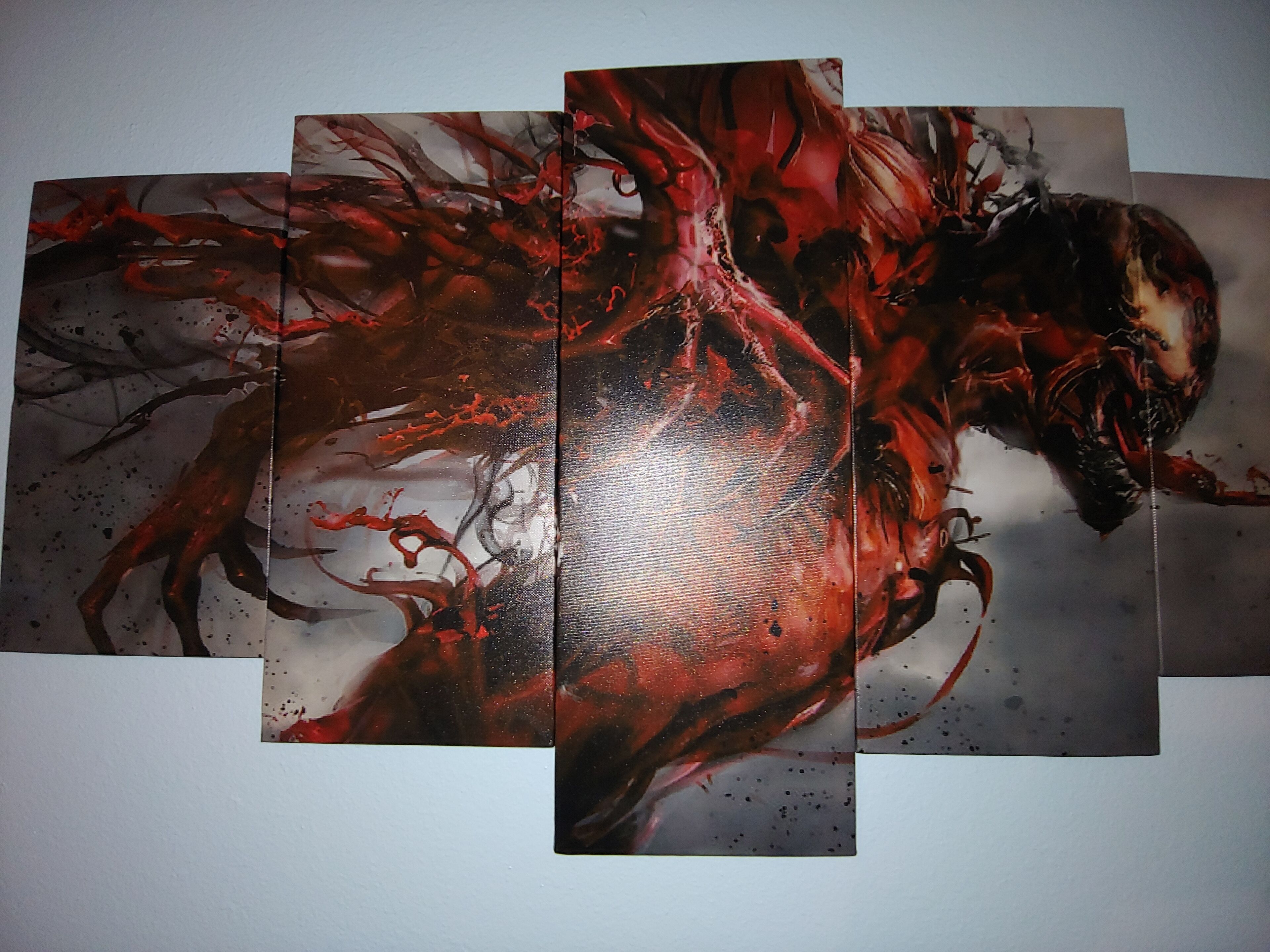 Une grande peinture abstraite aux couleurs rouge et noire, caractérisée par des formes dynamiques et des éclaboussures.