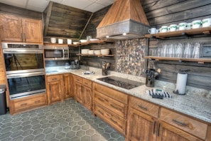 A kitchen with wooden cabinets, a microwave, an oven, and a granite countertop.