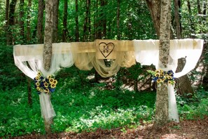 A tree with a heart-shaped decoration and floral arrangements. - Deer Crossing Lodge- PERFECT LODGE RETREAT FOR YOUR FAMLY REUNION (Sautee Nacoochee)