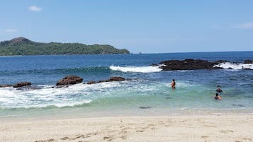 Una playa cerca, sillas reclinables de playa, toallas de playa