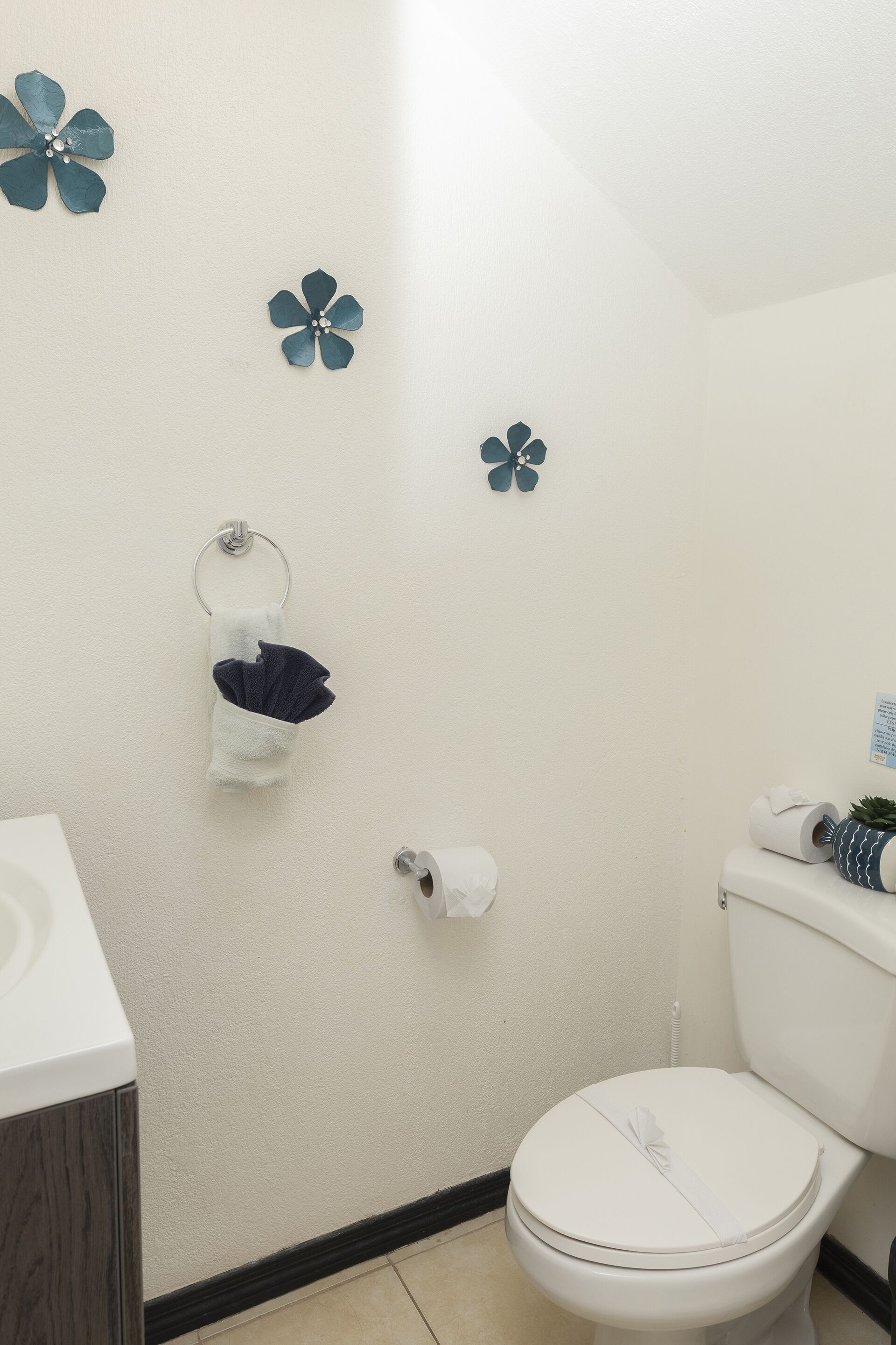 Une salle de bain équipée de toilettes, d’un lavabo et d’un porte-serviettes.