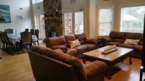 Open concept featuring stone fireplace, cozy living room seating, formal dining 