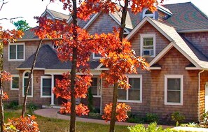 Stunning two-story building with a central entrance and brick siding, set amidst a beautifully manicured lawn and mature trees.
