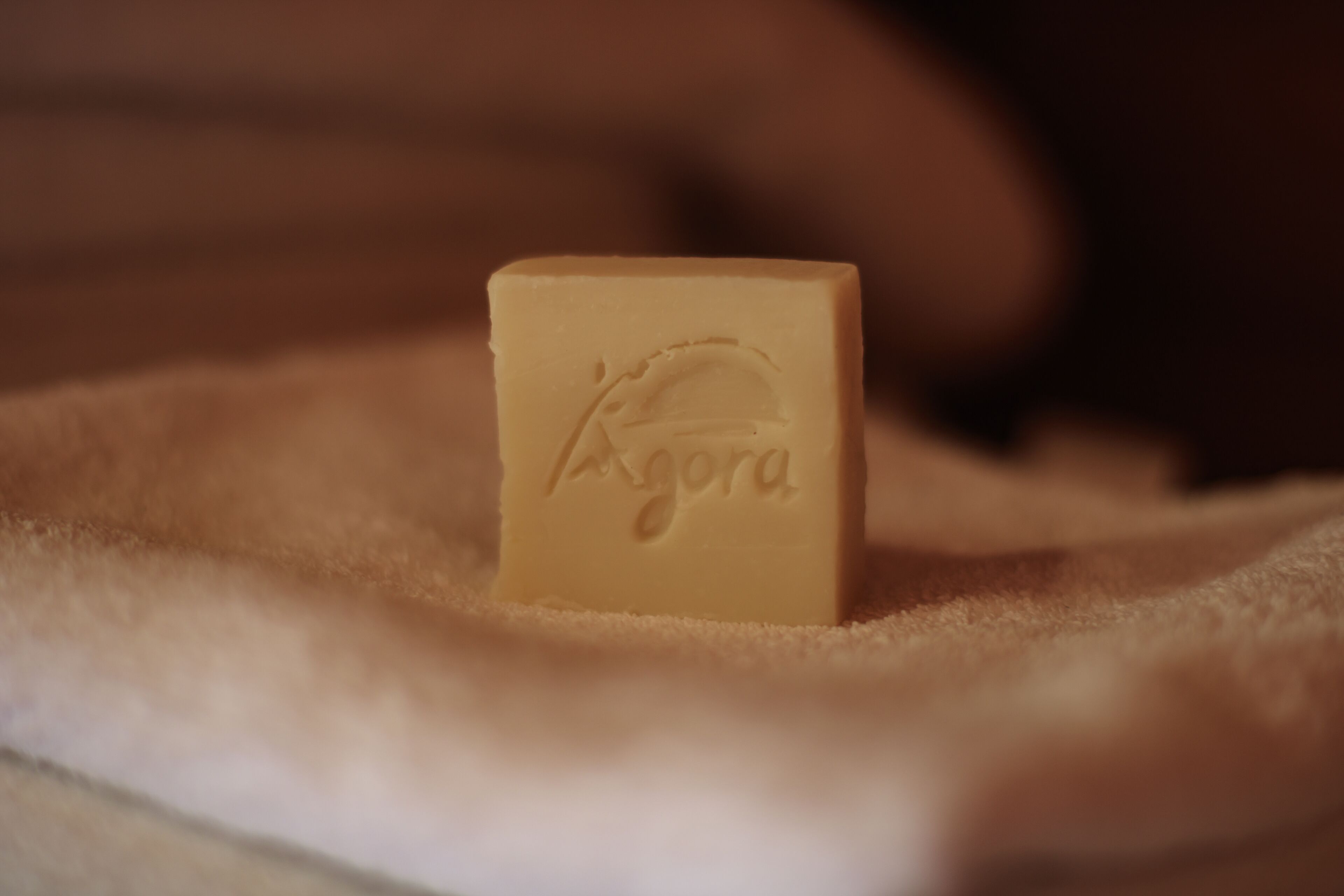 A small, square-shaped object with embossed text on a soft, textured surface.