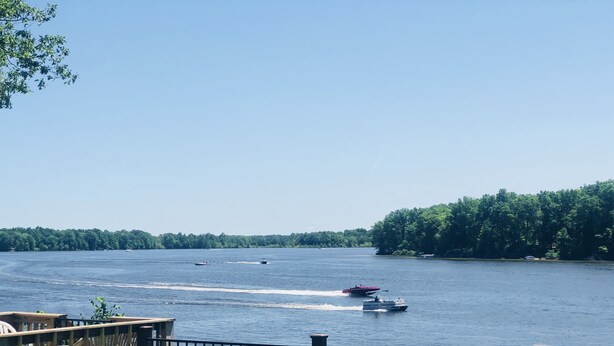 A lakeside view with a wooden deck and a metal railing. - Lakeside Paradise on Berlin  (Deerfield)