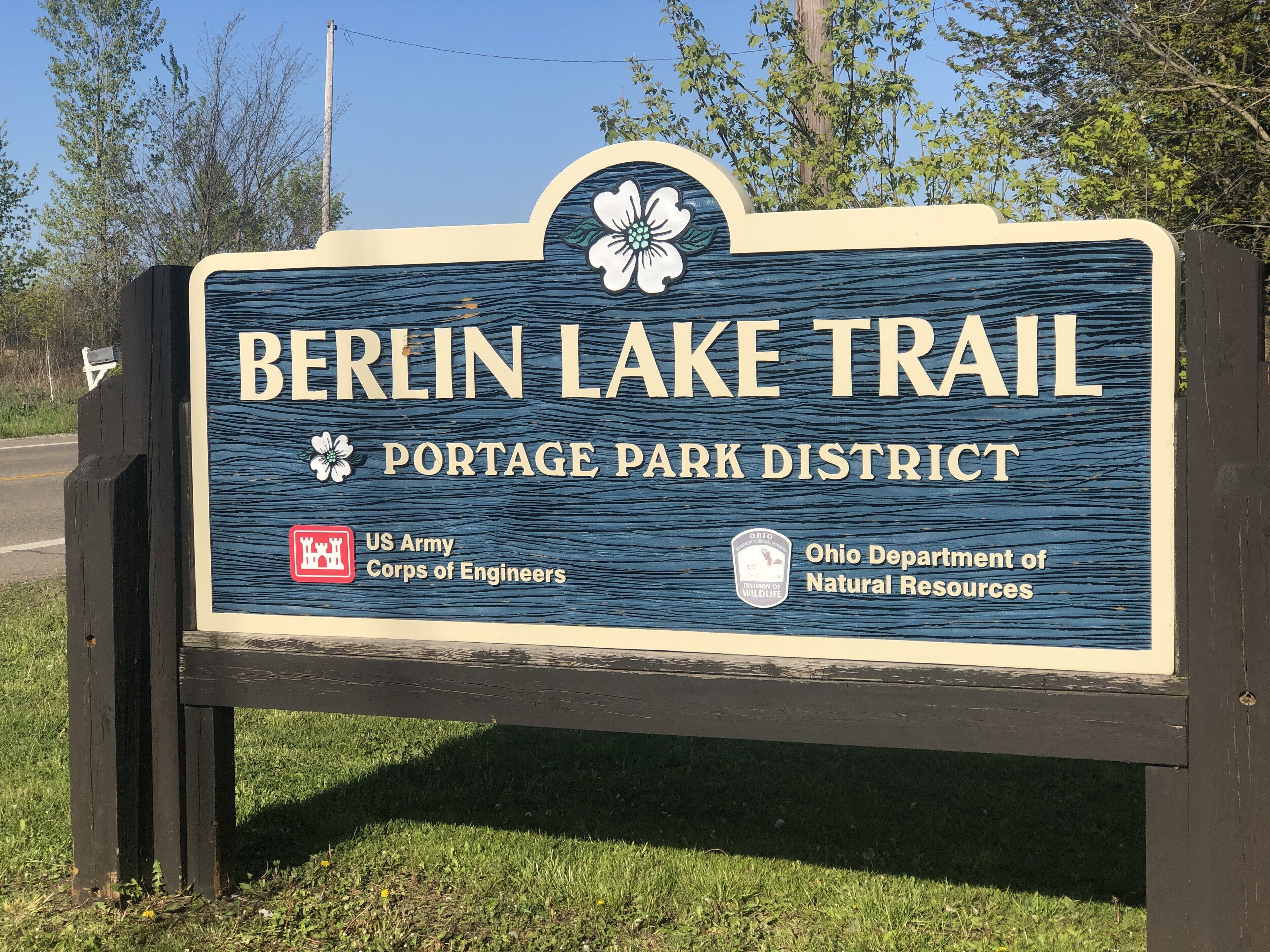 A sign for the Berlin Lake Trail in the Portage Park District, featuring logos of the US Army Corps of Engineers and the Ohio Department of Natural Resources.