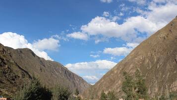 A mountainous landscape with a valley, houses, and trees.